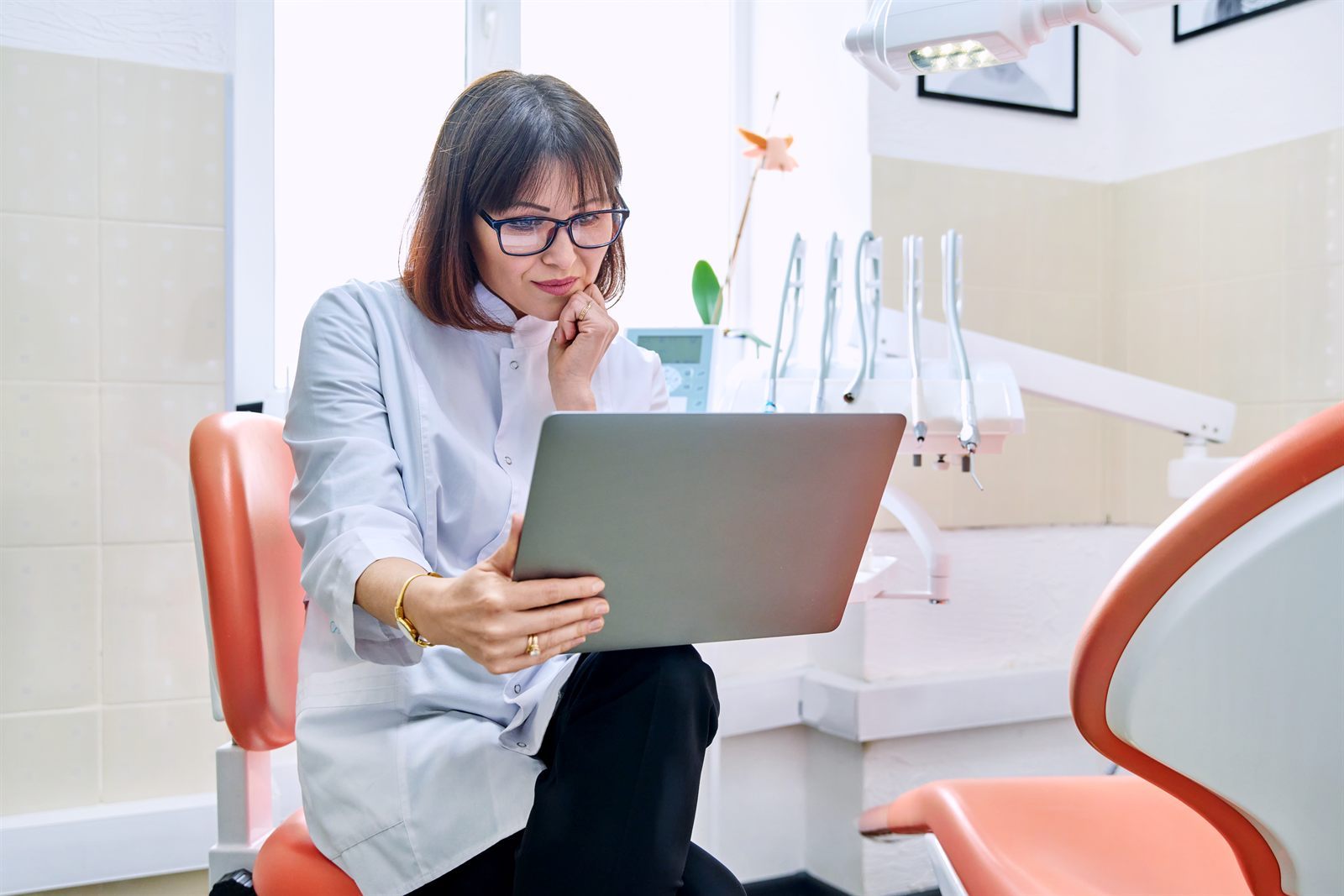 Dentist reviewing digital information on a laptop in a dental office